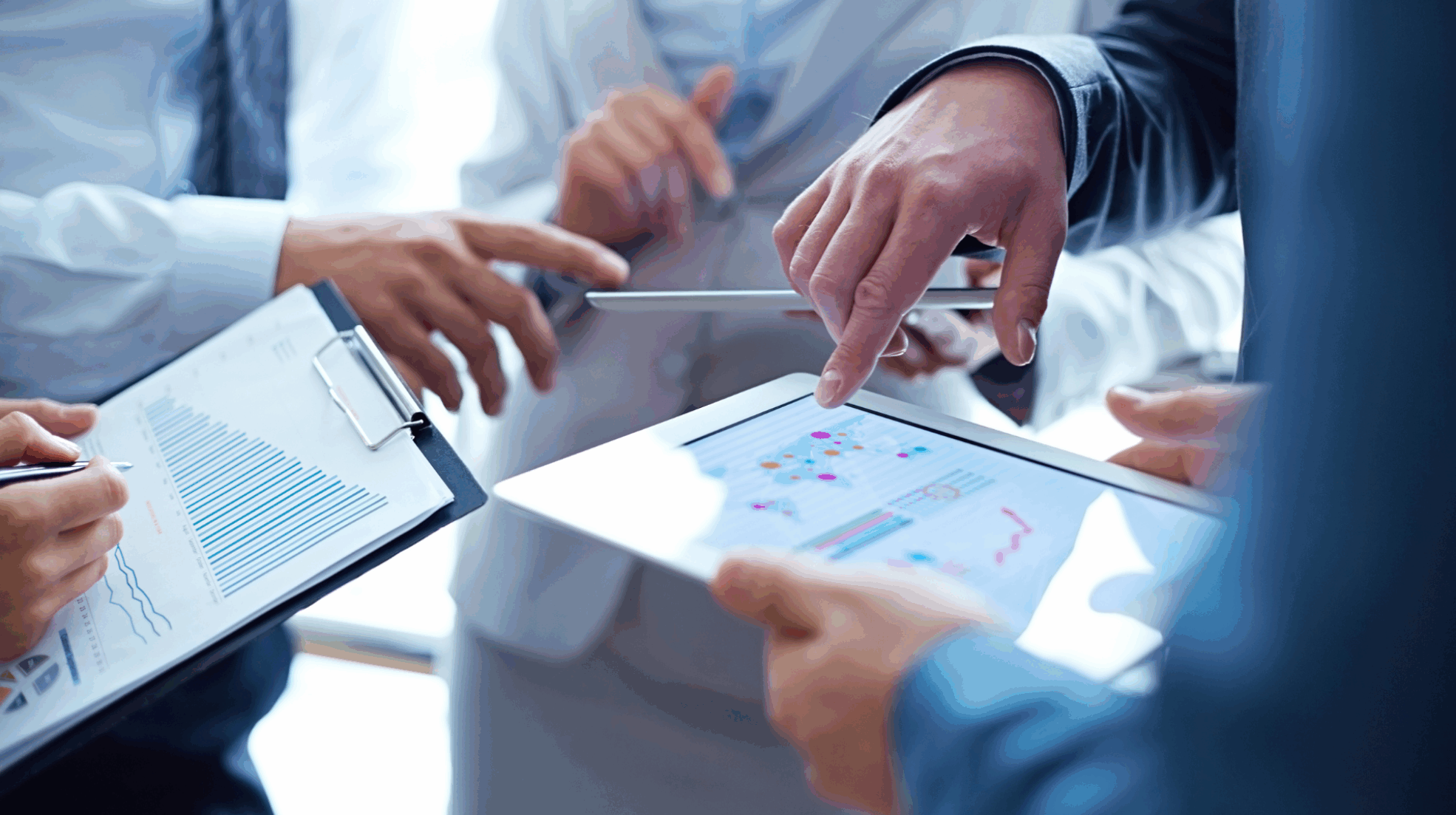 Business professionals collaborating on a tablet, discussing AI-driven group booking strategies for airline revenue growth.