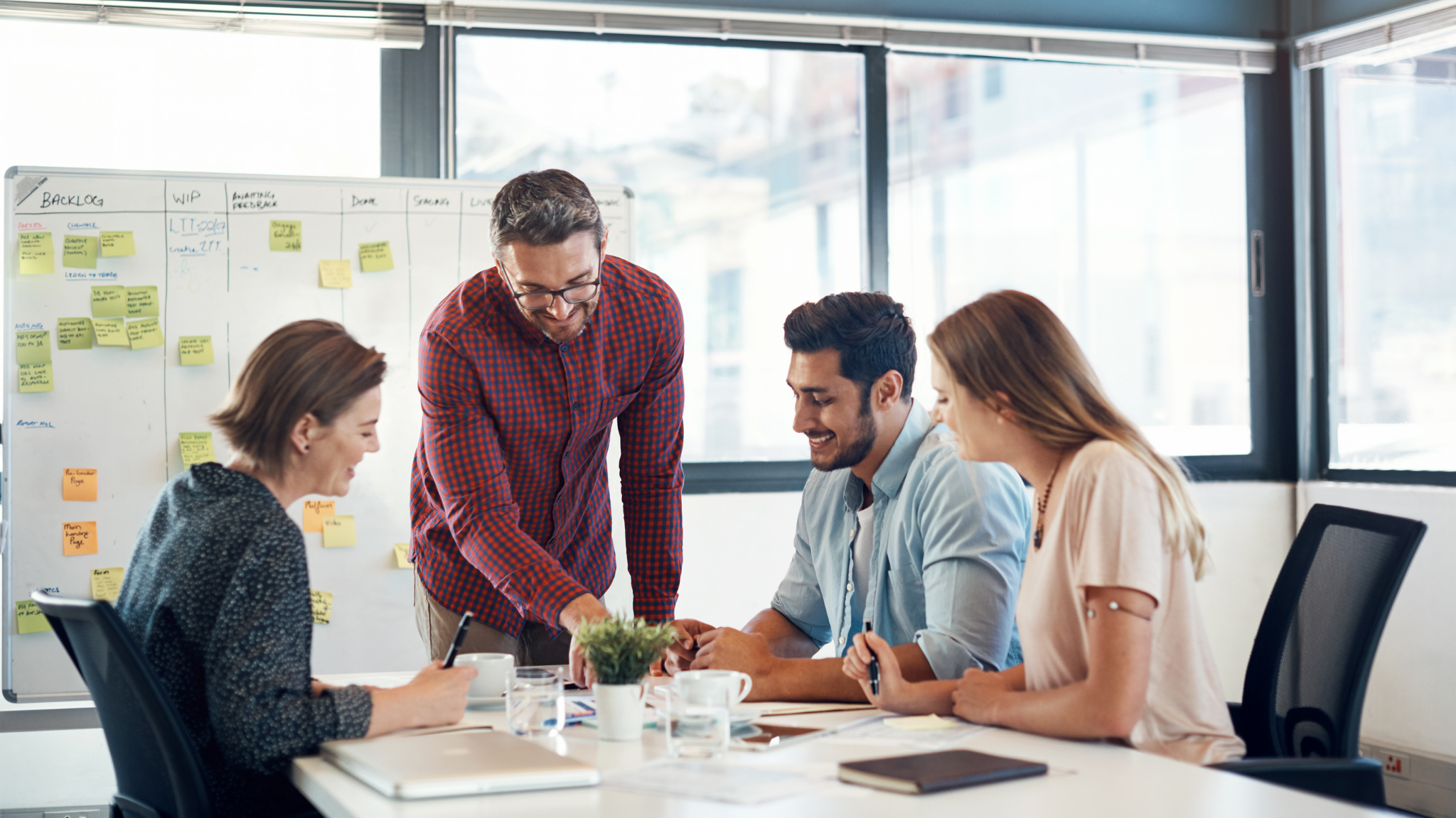 A gathering of individuals around a table, featuring a man and woman actively participating in the discussion about Top 5 Ways AI-Driven Dynamic Pricing Will Transform Group Sales in 2026