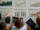 A group of people analyzing graphs displayed on a table during a meeting about 7 Benefits of Self-Service Group Portals for Airlines in 2026